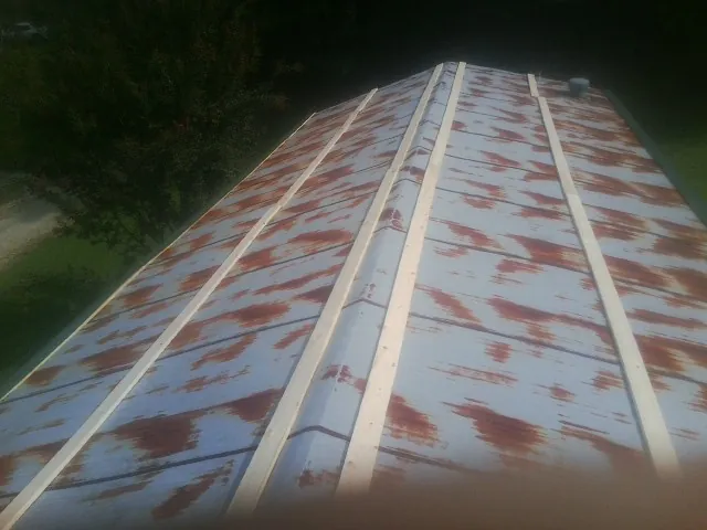 Rusted metal roof panels with new wood purlins before replacement — Storm Damage Roof Repair in Tavares by Roofing Brothers