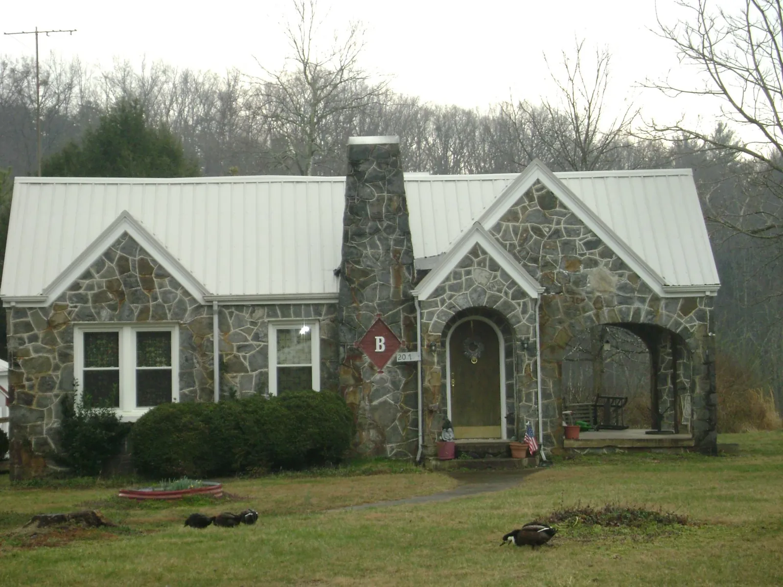 White metal roof on a stone cottage with steep gables in Tavares